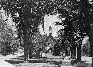 Image shows a partial front view of the church with a lot of trees in front of it.