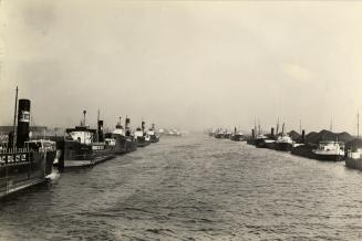 View of freighters, tankers and colliers berthed in ship channel