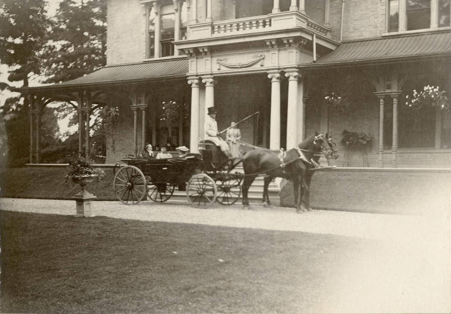 Image shows a horse carriage by the staircase of the building.