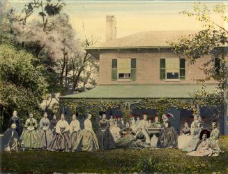 A group of thirty 19th-century people in front of a house with green shutters and a vine-covere…