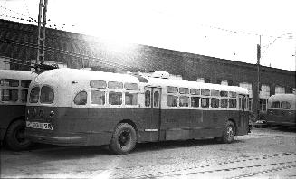  Image shows a few trolley buses by the building.

