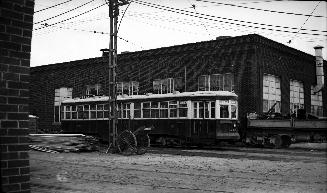 Image shows a few rail cars by the building. 