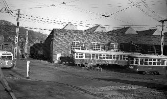 Image shows a few rail cars by the building.
