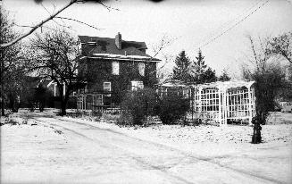 Image shows a two storey residential house in winter.