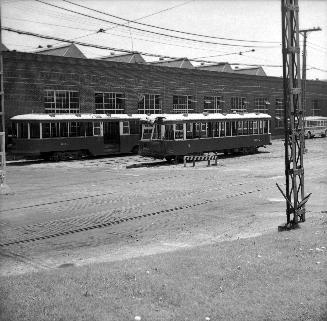 Image shows a few rail cars by the building.