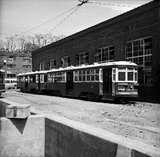 Image shows a few rail cars by the building.