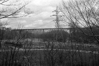 Image shows a river view with a bridge in the background.