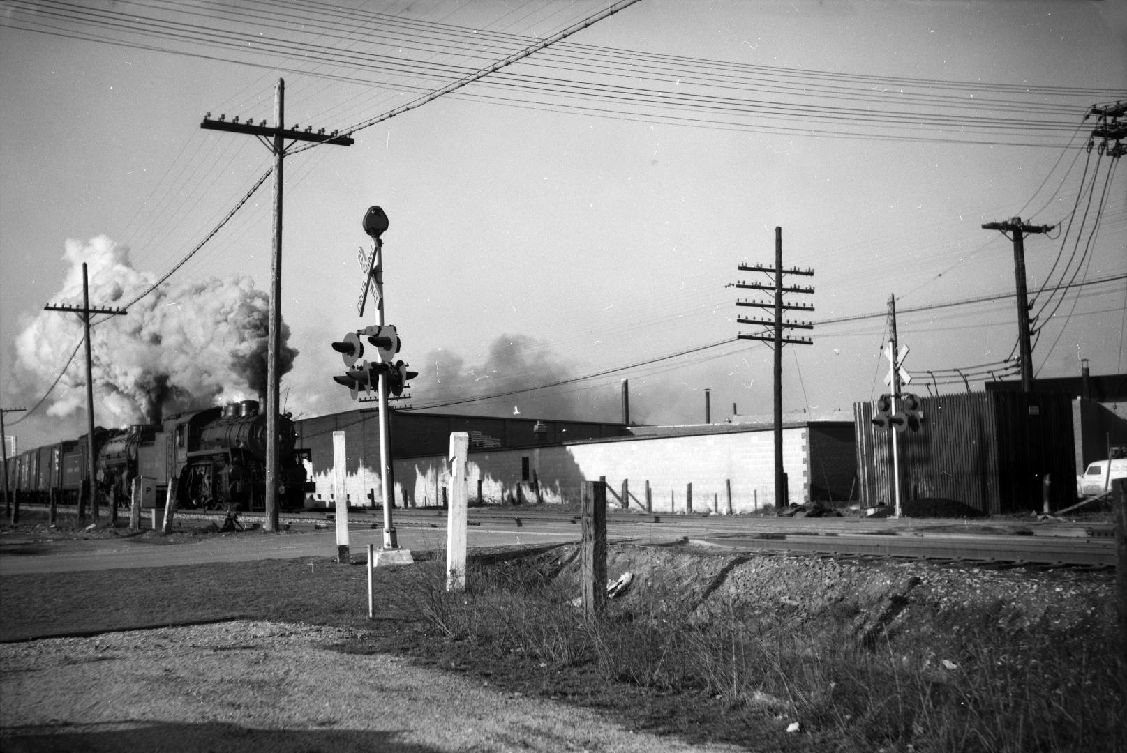 Image shows a train passing at the CP rail crossing.