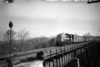 Image shows a CP rail bridge view with a passing train.