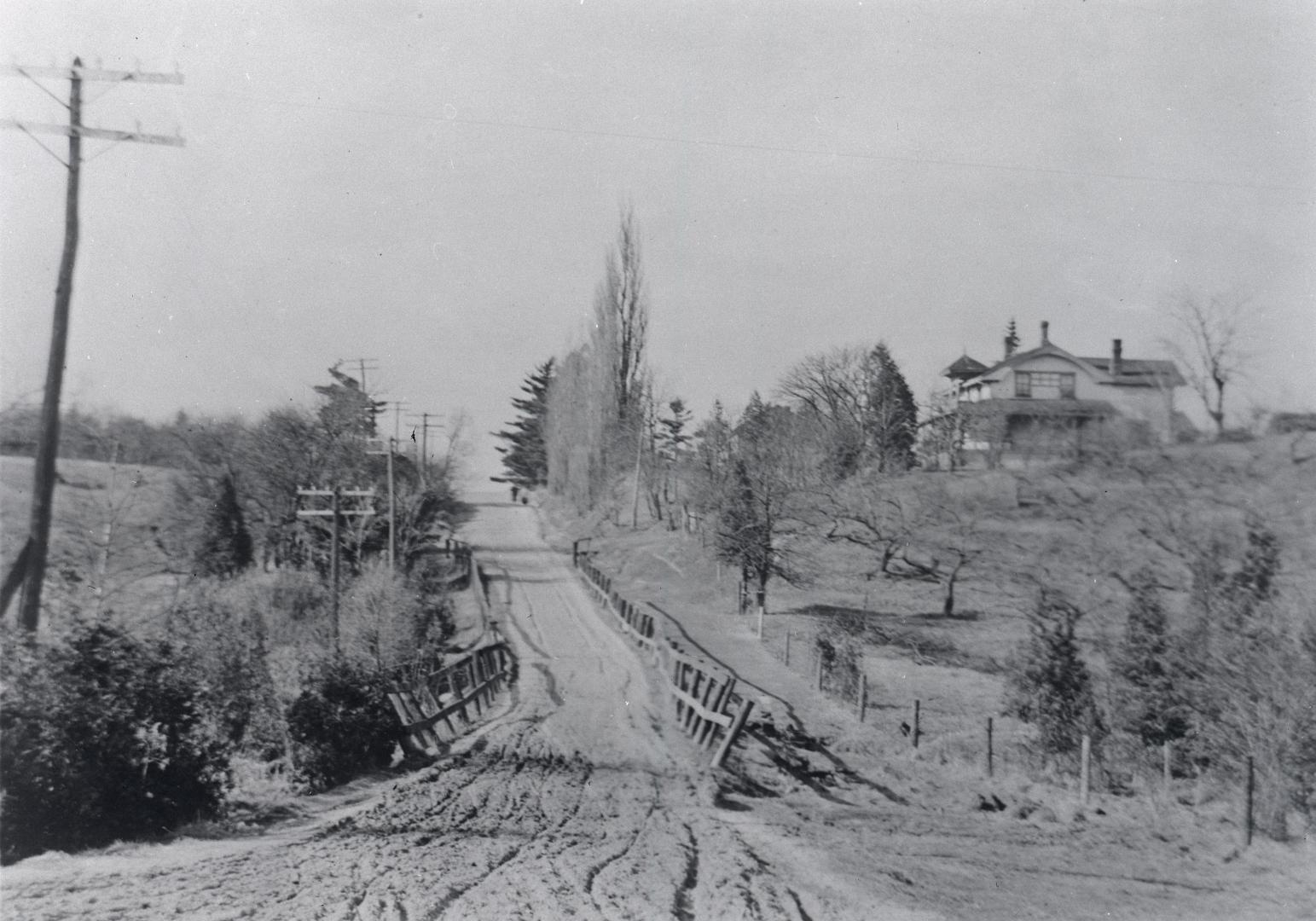 Bayview Avenue, looking north from Eglinton Avenue East. Image shows an unpaved road going up a ...