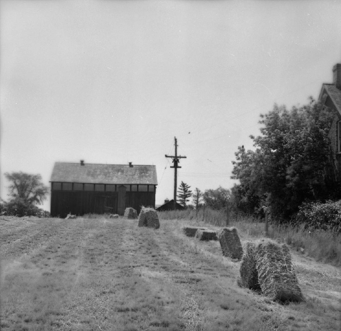 Image shows a field and a side view of a house.