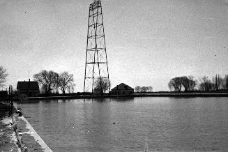 Historic photo from Wednesday, April 7, 1954 - Lighthouse keeper's house, Toronto Hydro feeder tower, & fog-horn station at Eastern Gap looking south in Toronto Island