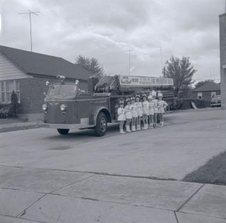 Image shows participants of the parade standing by the fire truck.