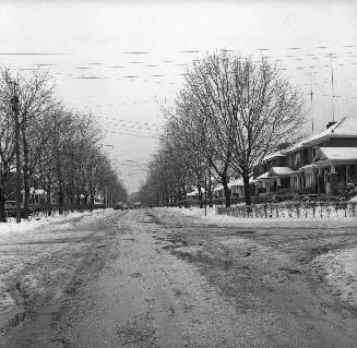 Image shows a street view in winter with the houses on both sides.