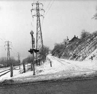 Image shows a road and tracks view in winter.