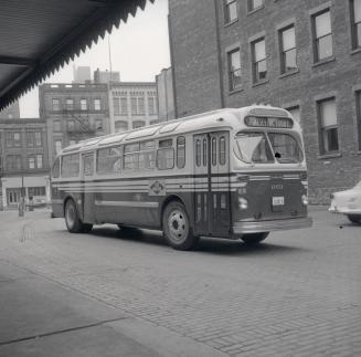 T.T.C., bus #1951, at T.T.C. head office, Yonge Street, northeast corner Front Street East, looking north at east side of building to Wellington Street East