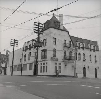 Image shows a three storey hotel building at the intersection.