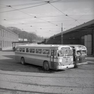 Image shows a few buses parked by the building.