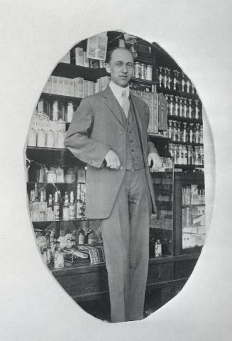Image shows a gentleman standing inside the drug store.
