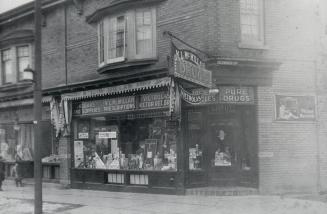 Image shows the front windows of the drug store that is located on the ground floor of a two st ...
