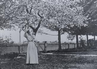 Historic photo from 1908 - Thomas Heys House Mrs. Owen Staples holding her daughter Isabella under flowering trees n.w. corner of Hogarth Ave.and Bowden St. in Riverdale