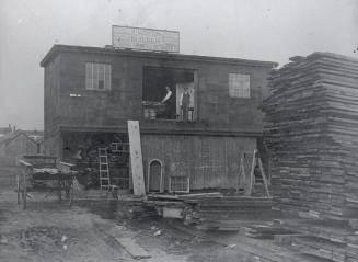 Image shows a builder shop with some construction material outside.