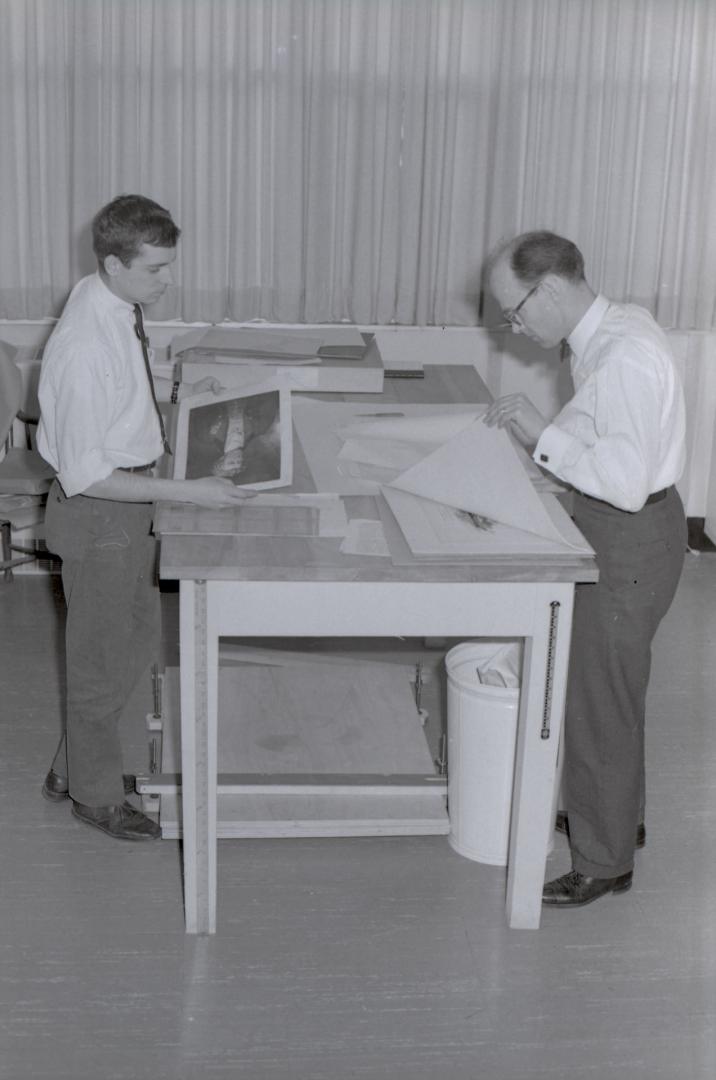 Two White men, one older and balding, one younger. Both wear ties, white dress shirts and dress…