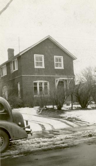 Image shows a limited view of a two storey house in winter.