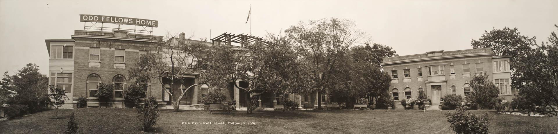Image shows Ontario Odd Fellows home with a lot of lawn space at the front and some trees aroun…