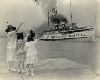 Image shows a lady and two girls at the Harbour waving to the leaving ship.