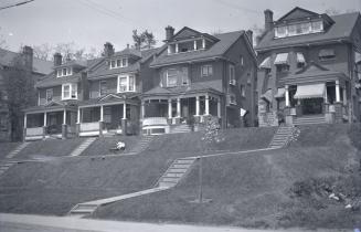 Image shows a row of residential house on a small hill.