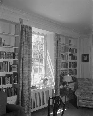 Image shows interior of the house with bookshelves on both sides of the window.