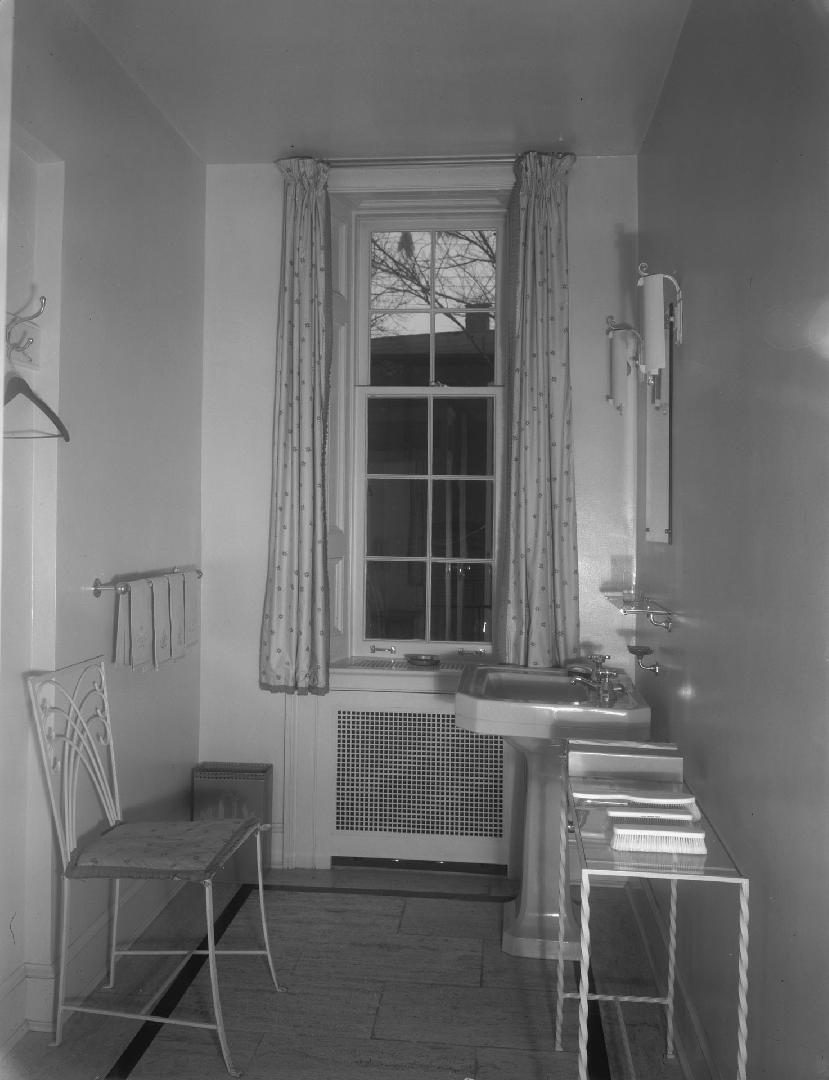 Image shows an interior of the washroom. There is a sink, a chair, a small table against the wa ...