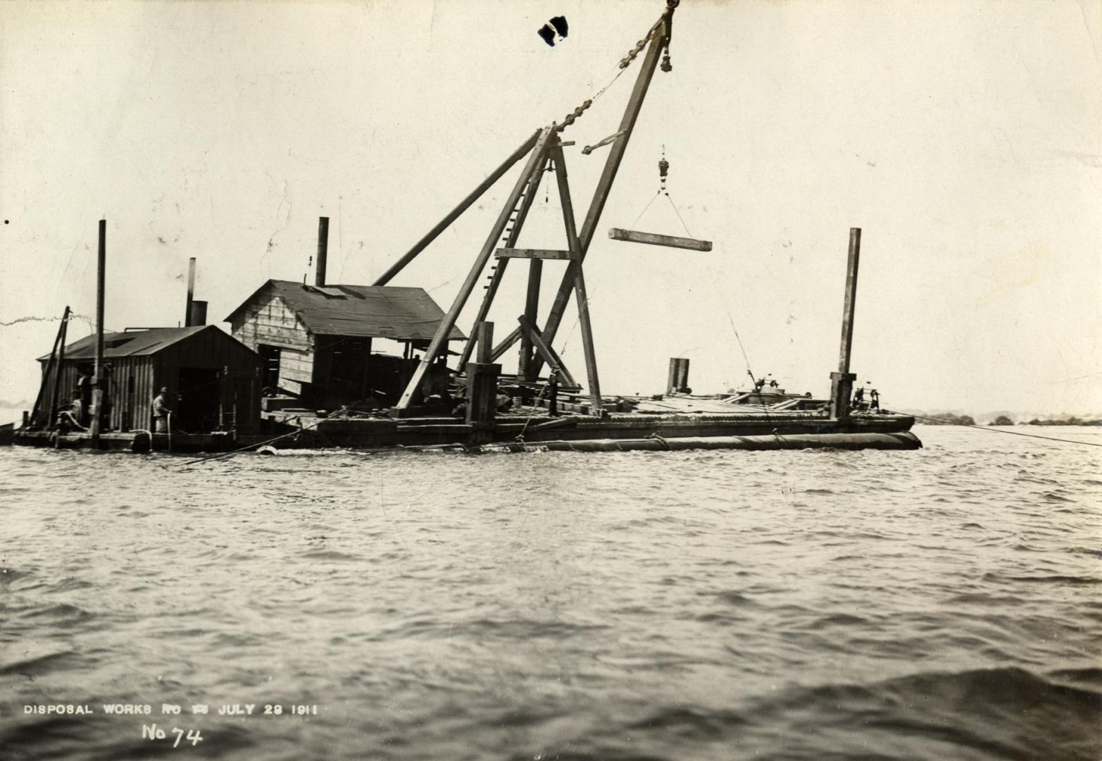 Image shows construction work of laying pipes in the lake in progress.