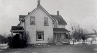 Image shows a two storey Silas Hill home, Toronto, Ontario. There are some trees and bushes aro ...
