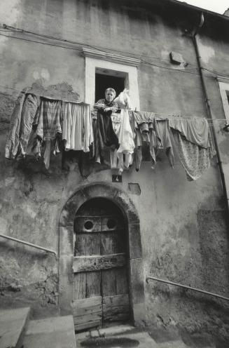 Woman pins laundry on a clothesline in Castelfranco, Italy