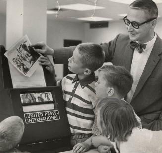 City Editor Dave McKee and children view the UPI wire photo machine