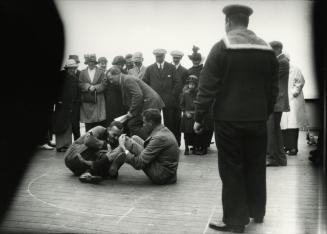 Arthur Conan Doyle watching leg wrestling aboard ship, 1914