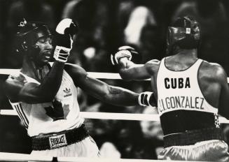 Lennox Lewis of Canada ducks away from a wild left thrown by Jorge Gonzales of Cuba in 91K gold medal fight at Convention Centre today. Jorge must have landed a few as he won decision in dull bout