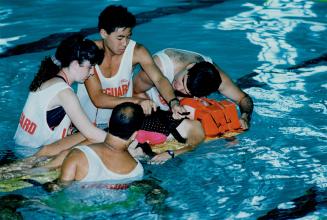 Lifeguards Eliana Klier, Jens Tan, Lian Soudack and Rich Sordet respond to a mock drowning in a pool by reviving victim Tracy Moreland. They were inst(...)