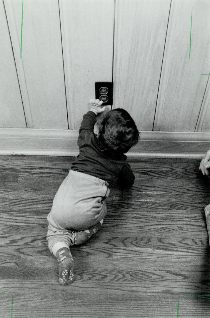 Look out: Besides the usual dangers - here Gabriel Freedman reaches for a wail socket - apartments present special dangers for toddler tenants