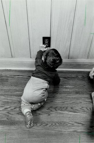 Look out: Besides the usual dangers - here Gabriel Freedman reaches for a wail socket - apartments present special dangers for toddler tenants