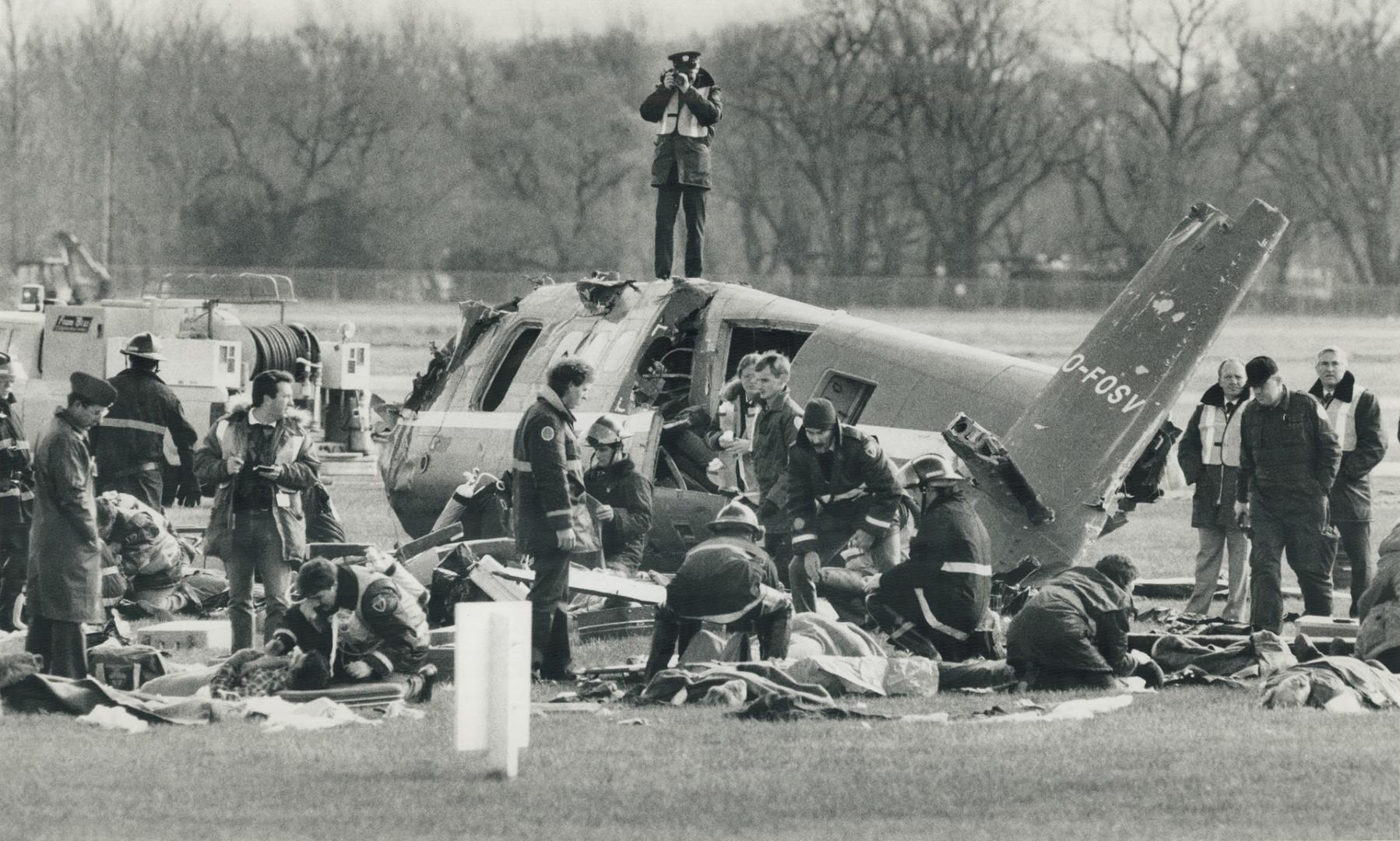 A 'crash' course in working together. A fire department photographer finds a high perch at yesterday's mock disaster at Toronto Island Airport