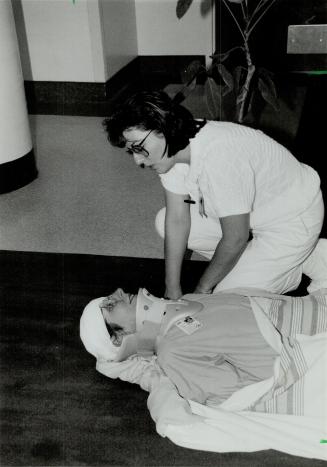 Comforting Words: Nursing assistant Julieta Viveiros makes sure patient Karen Stirling is comfortable during a mock evacuation at Mississauga Hospital