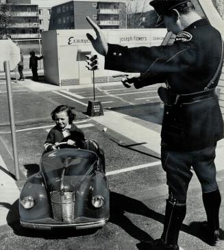 Traffic officer Russ Little instructs a young driver in the correct way of making a right hand turn