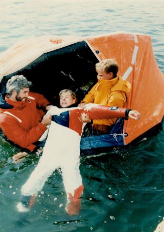 Pulled to life, Ian Salisbury, left, and Dean Mayke, right pull Spence Evans aboard a life raft during Humber College's Small Craft and Marine Technol(...)