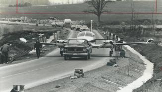 Grounded. A Cessna 411 from which 7 walked away unhurt following an emergency landing early yesterday is towed back to Buttonville Airport. The plane,(...)
