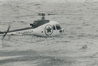Hank Emson, afloat in water at lower right after plane crash, awaits the first rescue attempt by Ranger helicopter piloted by Andy Stevens