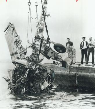 Mangled wreckage of vintage World War II Fairey Firefly in which Alan Ness crashed to death is raised in three pieces from Lake Ontario by barge-mount(...)