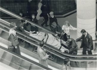 Man falls at Eaton Centre. Vincent Gray, 23, is carried away on a stretcher after falling three storeys in the mall of the Eaton Centre yesterday. He (...)